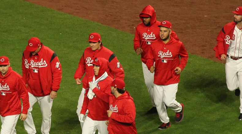 The Reds celebrate a victory over the Braves on Monday, April 23, 2018, at Great American Ball Park in Cincinnati. David Jablonski/Staff