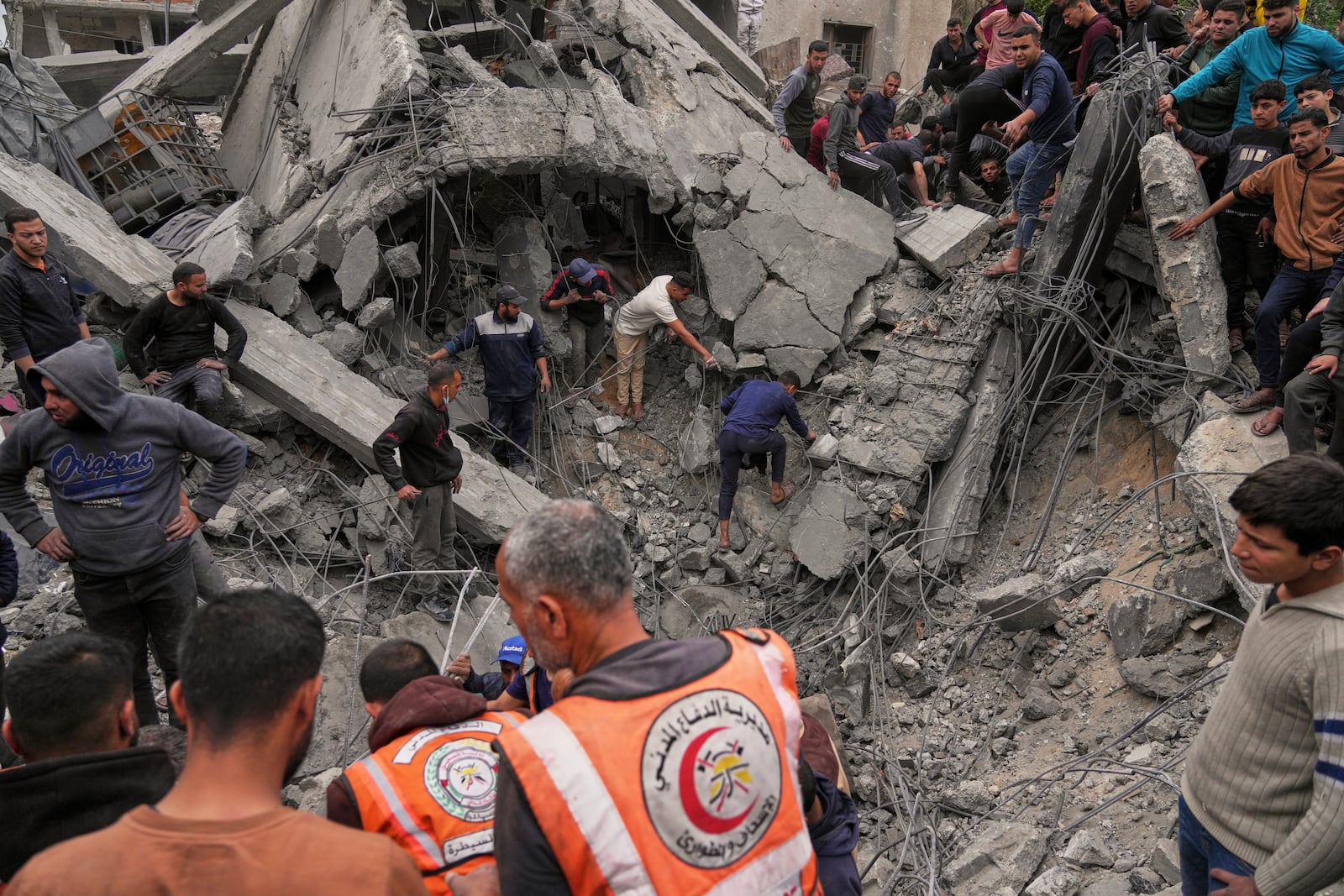 Volunteers and emergency workers search for bodies or survivors from the rubble of the Manoun family's house after it was targeted by an Israeli army strike in Jabalia al-Balad, Gaza City, Sunday, April 13, 2025. (AP Photo/Jehad Alshrafi)