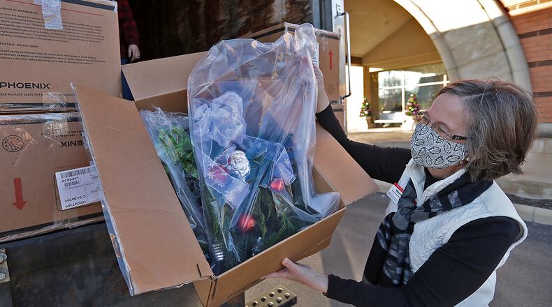 Clark County Master Gardener Wendy May looks at one of the door swags the master gardeners made for the patients at the Springfield Cancer Center as the swags were delivered  on Wednesday. BILL LACKEY/STAFF