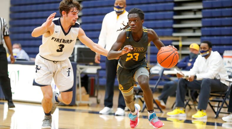 Springfield High School guard Micha Johnson drives past Fairmont's Ryan Soter during a game last season Trent Arena. Michael Cooper/CONTRIBUTED