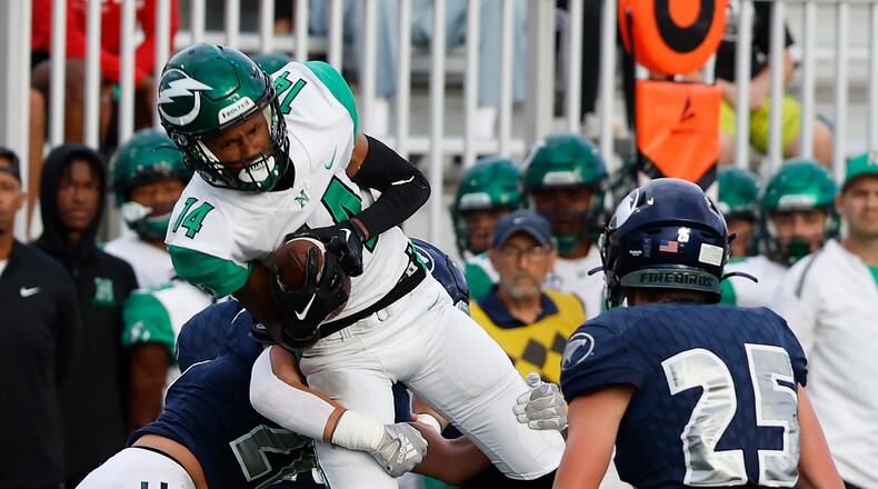 Northmont's Daniel Ivory is tackled by Fairmont's Stevie Doty as he catches a pass. BILL LACKEY/STAFF