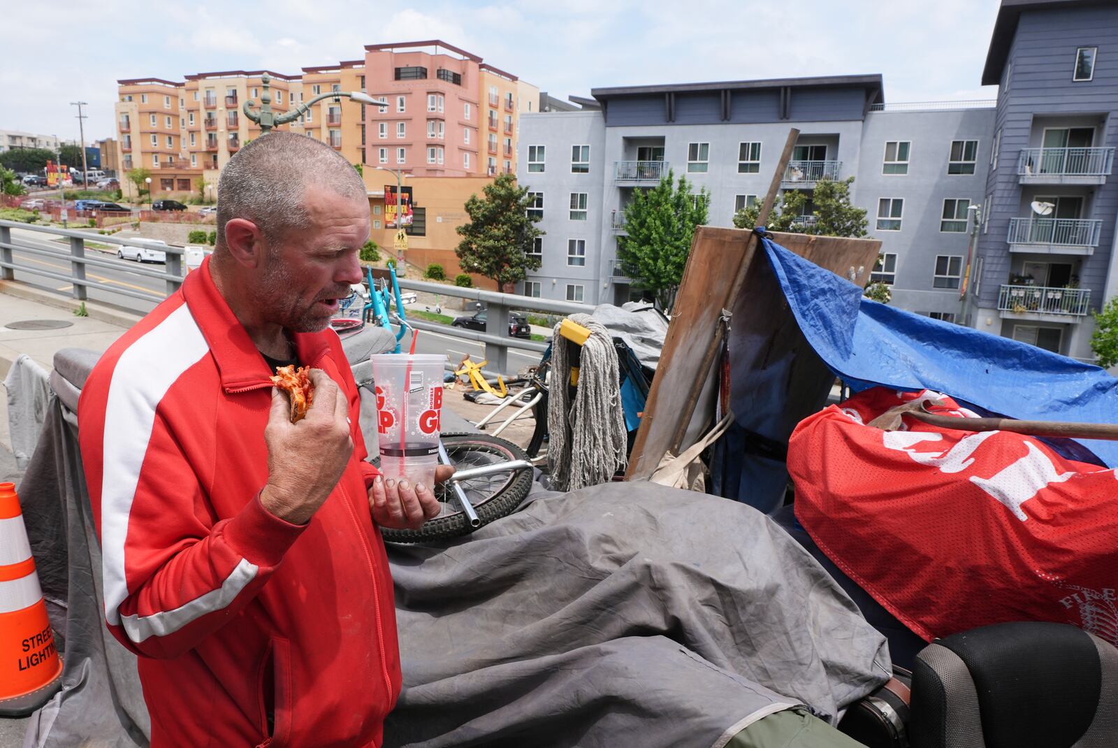 Scott Robertson Serge eats lunch in a homeless encampment where he currently lives, Monday, May 12, 2025, in Los Angeles. (AP Photo/Damian Dovarganes)