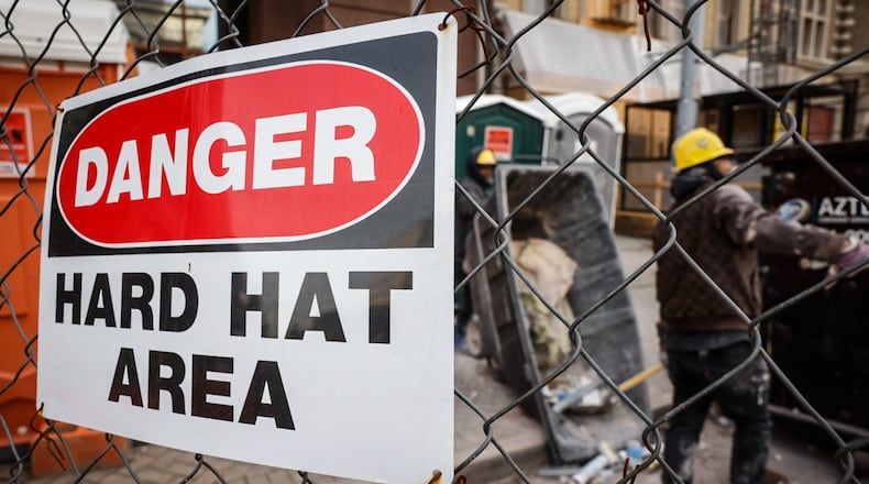 Construction workers remove debris from the Dayton Arcade on the Third Street side, Friday January 5, 2024. JIM NOELKER/STAFF