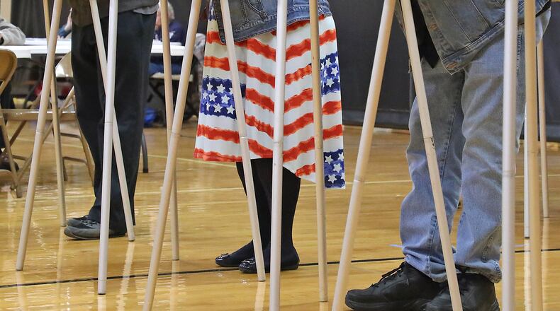 A woman was showing her patriotic spirit with the stars and stripes on her dress as she voted in a voting booth at Tecumseh High School. BILL LACKEY/STAFF