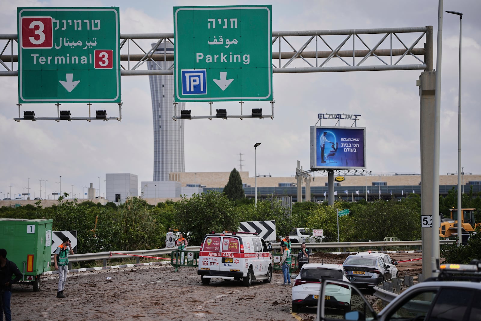 Israeli security forces inspect the site where the Israeli military said a projectile fired by Yemen's Houthi rebels landed in the area of Ben Gurion International Airport near Tel Aviv, Israel, on Sunday, May 4, 2025. (AP Photo/Ohad Zwigenberg)