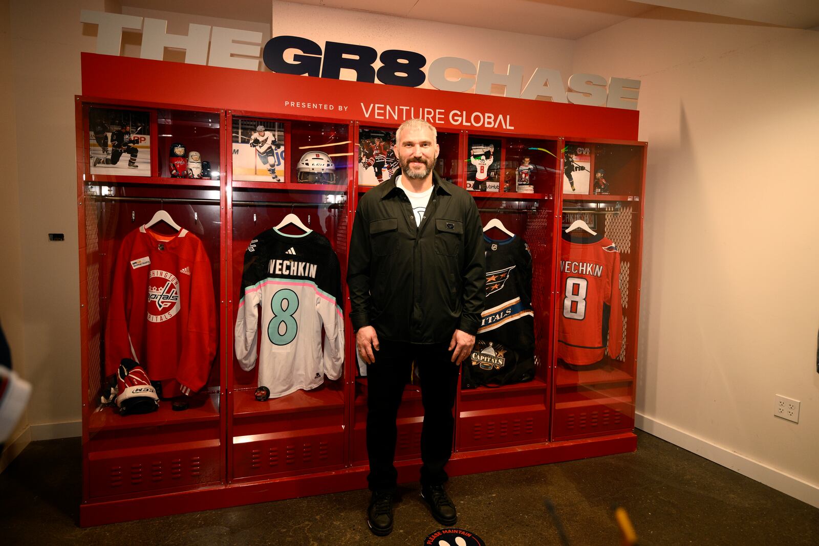 Washington Capitals left wing Alex Ovechkin poses by a locker display at the GR8 city celebration to honor him for scoring 895 NHL hockey career goals, Friday, April 11, 2025, in Washington. (AP Photo/Nick Wass)