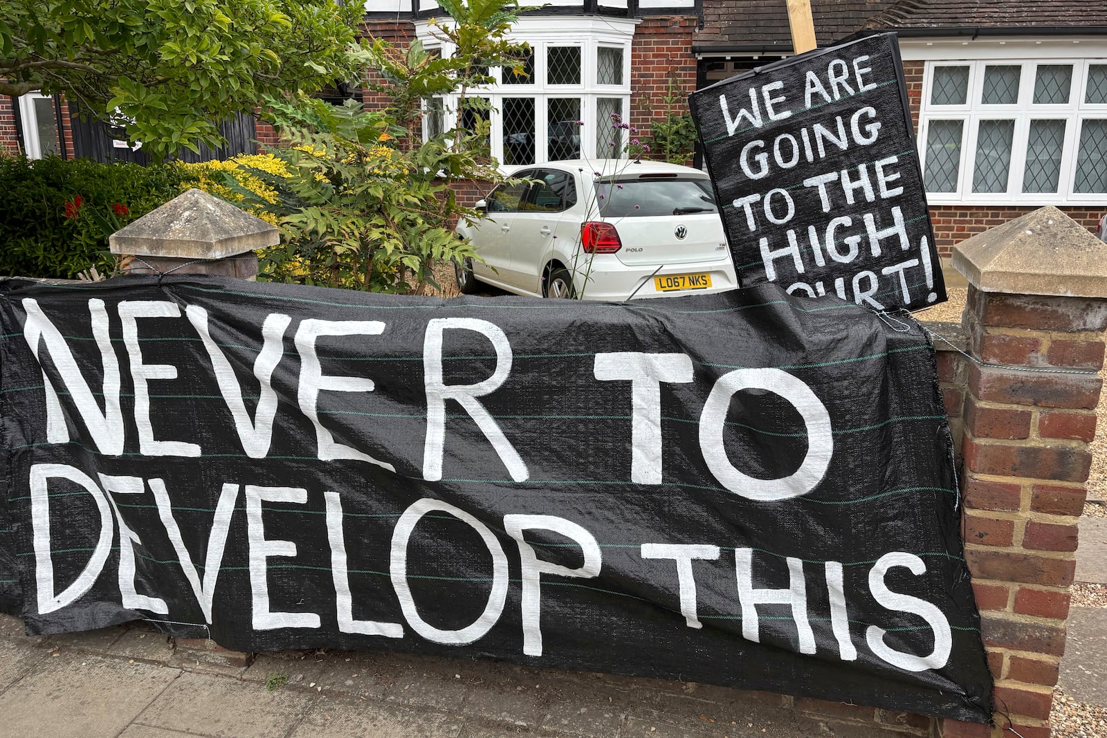 A banner opposed to Wimbledon's major expansion plan is placed outside a house leading to the All England Club where the Wimbledon Tennis Championships take place in London, Saturday, July 5, 2025. (AP Photo/Tony Hicks)