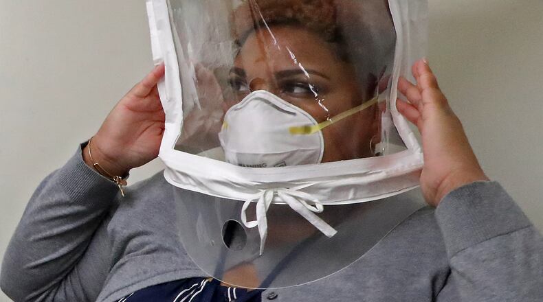 Lenora Pass moves around to make sure her N95 protective mask stays in place during her fit test Thursday. BILL LACKEY/STAFF