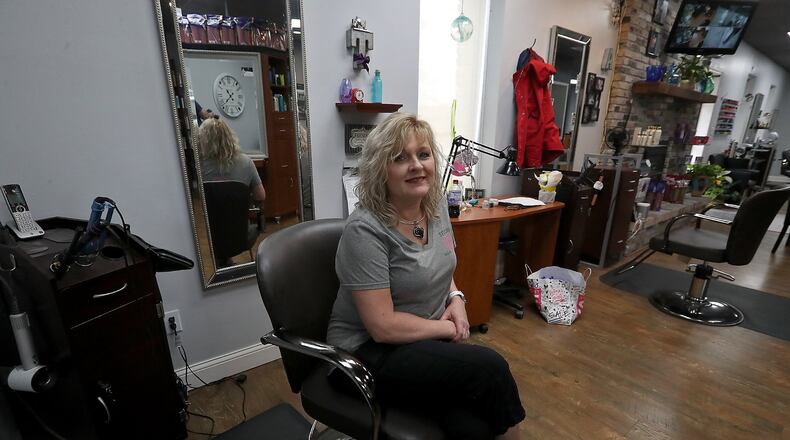 TaBetha Biggs, owner of Studio B Salon and Spa, sits at her station in her empty salon Tuesday. As the governor starts the state’s economy back up, local stylists and barbers are left wondering when they can reopen. BILL LACKEY/STAFF