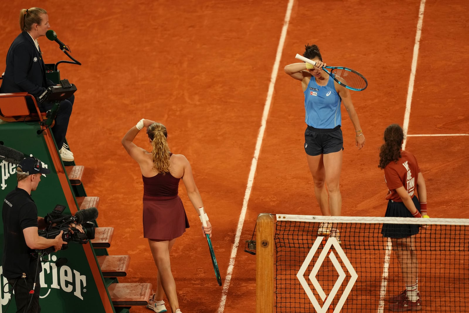 France's Lois Boisson, centre right, and Russia's Mirra Andreeva attend a break during their quarterfinal match of the French Tennis Open at the Roland-Garros stadium in Paris, Wednesday, June 4, 2025. (AP Photo/Aurelien Morissard)