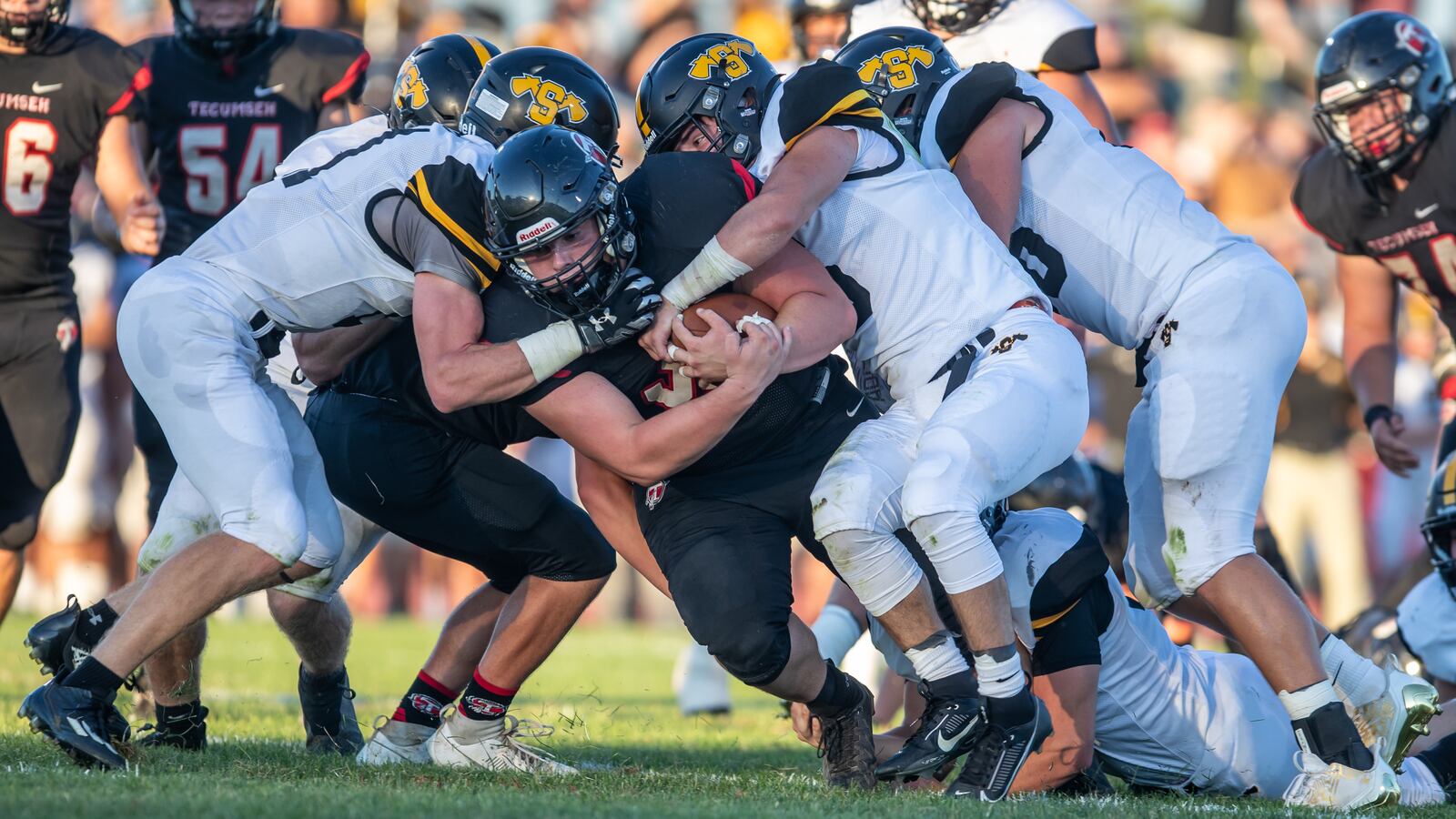 Tecumseh High School senior Connor Bledsoe is tackled by a group of Shawnee defenders during their game on Friday night at Spitzer Stadium in New Carlisle. The Braves won 42-14. Michael Cooper/CONTRIBUTED