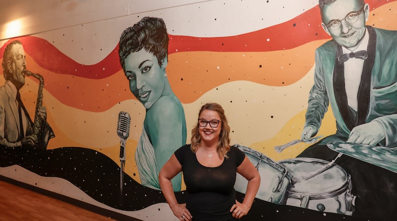 Cheyenne Shuttleworth poses for a portrait by a mural she created at Hi★Hat Social on Wednesday, Sept. 3, 2025, in Springfield. JOSEPH COOKE/STAFF