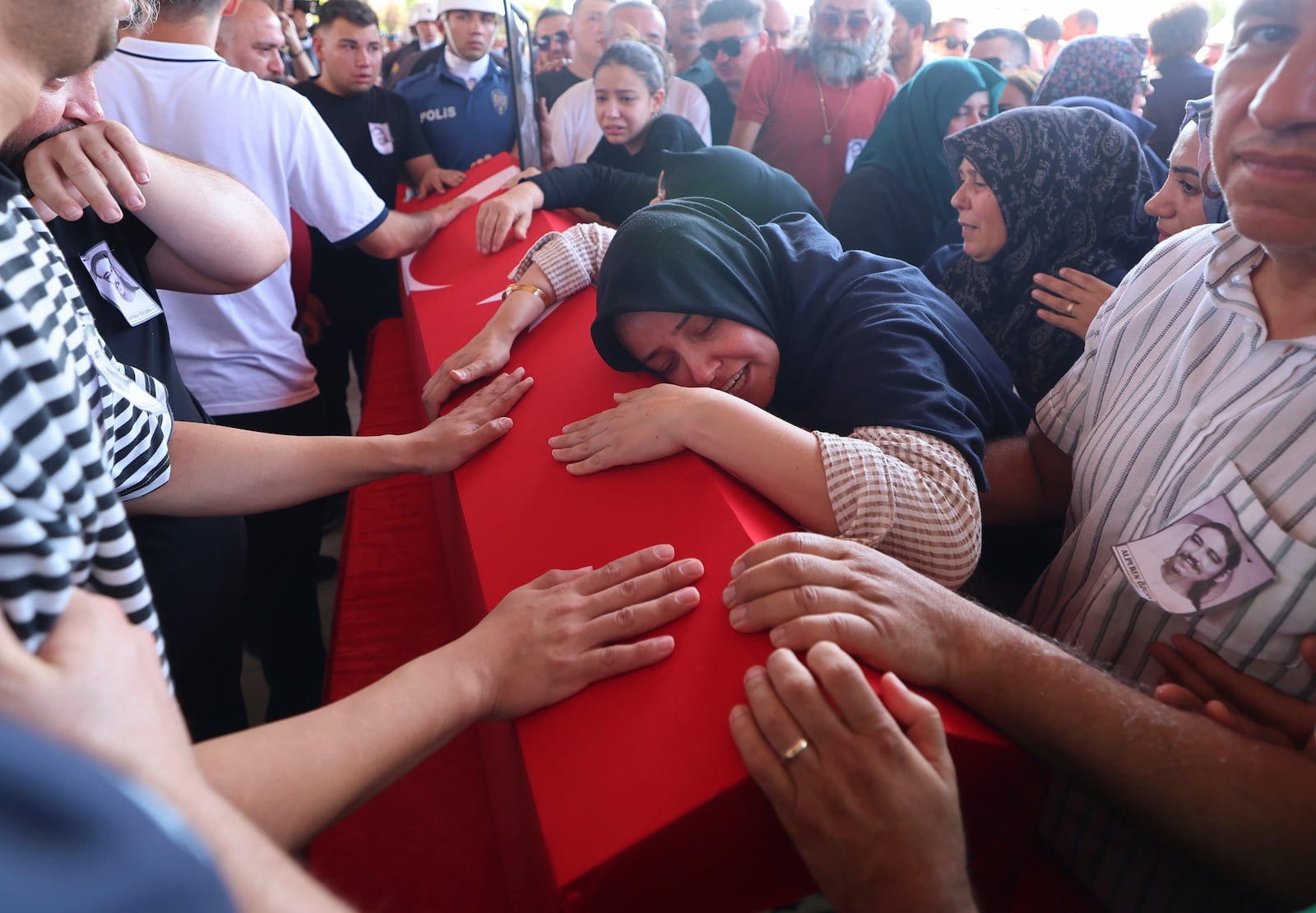 Relatives and friends mourn during the funeral of five rescue volunteers killed while battling a wildfire in northwestern Eskisehir province, in Ankara, Turkey, Thursday, July 24, 2025. (Yavuz Ozden/Dia Photo via AP)