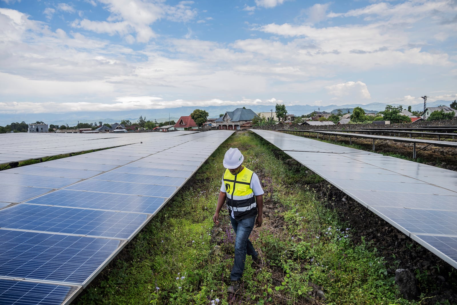 Katembo Waziwazi, a Nuru technician, walks through a solar farm in Goma, Congo, Goma May 23, 2025. (AP Photo/Moses Sawasawa)
