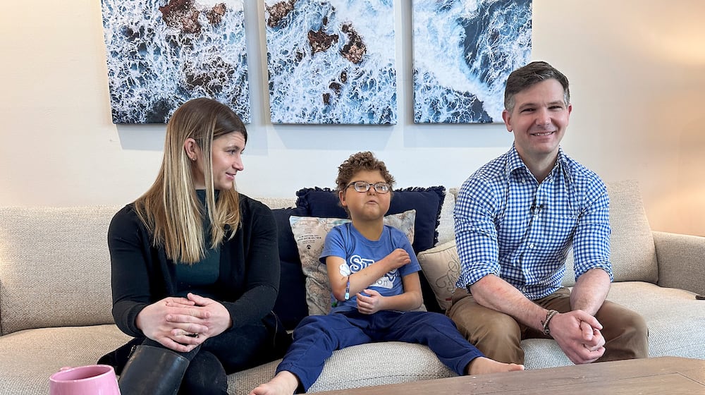 Logan Coyle, nine years old, center, answers questions during an interview with his parents Rebecca Coyle, left, and Logan Coyle, Feb. 10, 2026, in New York. (AP Photo/Phil Marcelo)