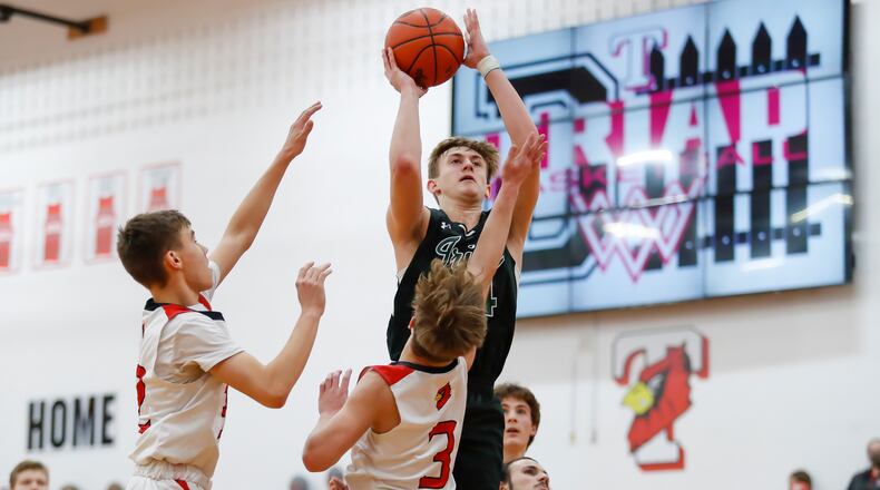 Cutline: Catholic Central High School sophomore Tyler Galluch shoots the ball over two Triad defenders during their game on Friday night in North Lewisburg. The Irish won 85-58. CONTRIBUTED PHOTO BY MICHAEL COOPER