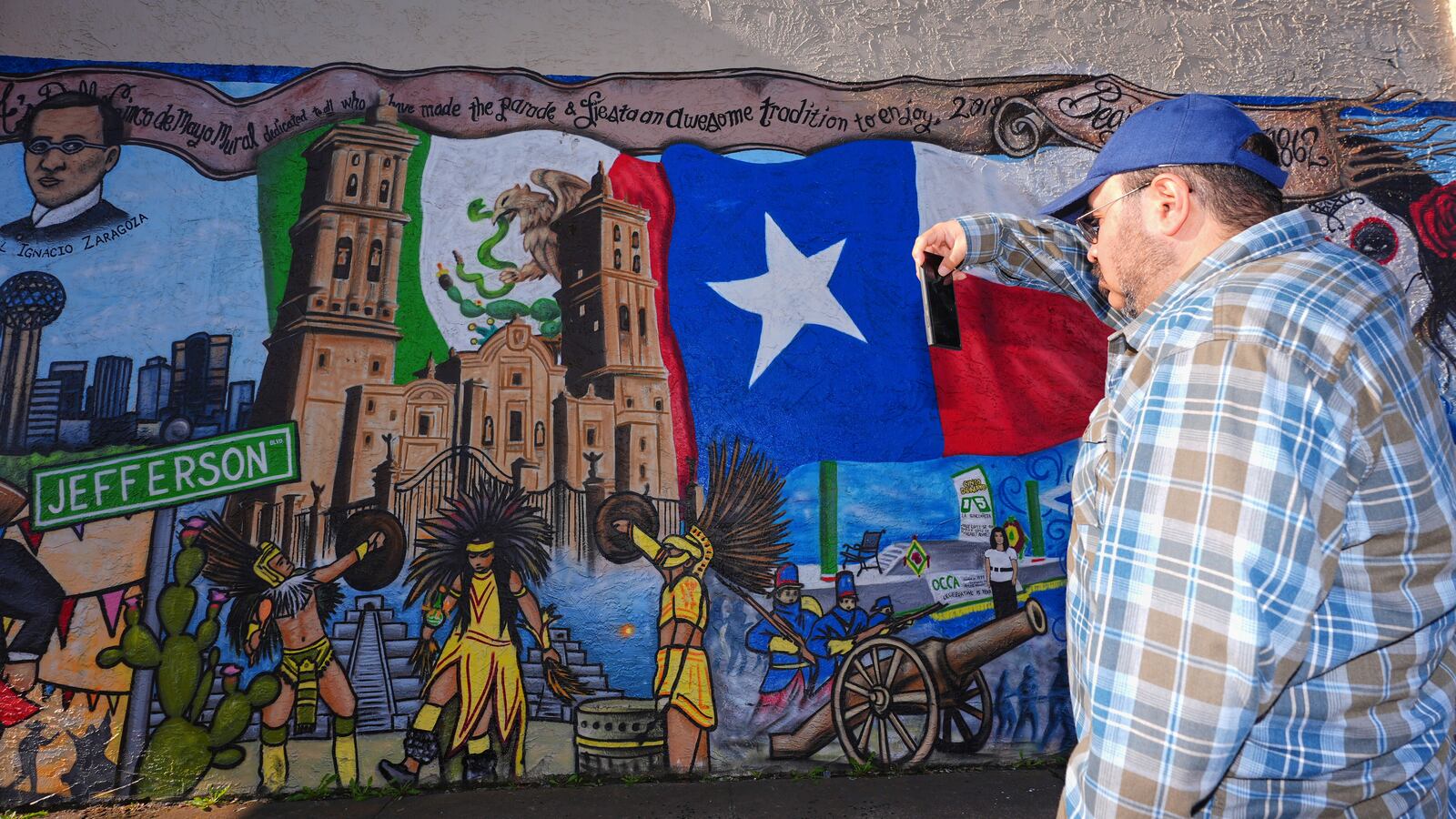 Rolando Salas, originally for Mexico, photographs a mural made by artist Jesus Alba to commemorate the 1862 battle of Puebla between the French and Mexican army during a Cinco De Mayo celebration in the Oak Cliff section of Dallas, May 3, 2025. Salas called the May 5th holiday, "A celebration of us." (AP Photo/LM Otero)