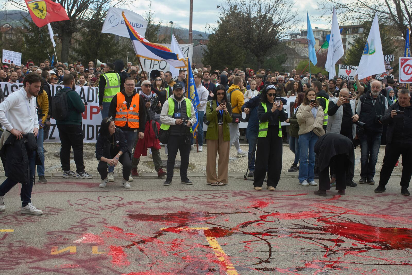 Protesters spill red paint in front of a local police station during an anti-corruption protest led by university students in the southwestern town of Novi Pazar, Serbia, Saturday, April 12, 2025. (AP Photo/Marko Drobnjakovic)