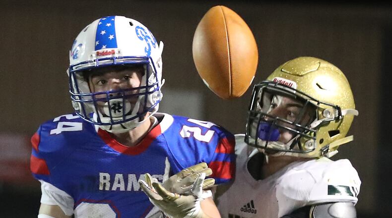 Greeneview's Craig Finley and Catholic Central's Ashton Young battle for a pass during Friday's game. BILL LACKEY/STAFF