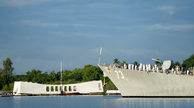 Sailors aboard the the USS Decatur render honors while passing the USS Arizona Memorial and the sunken battleship the USS Arizona during the 82nd Pearl Harbor Remembrance Day ceremony on Thursday, Dec. 7, 2023, at Pearl Harbor in Honolulu, Hawaii. (AP Photo/Mengshin Lin)
