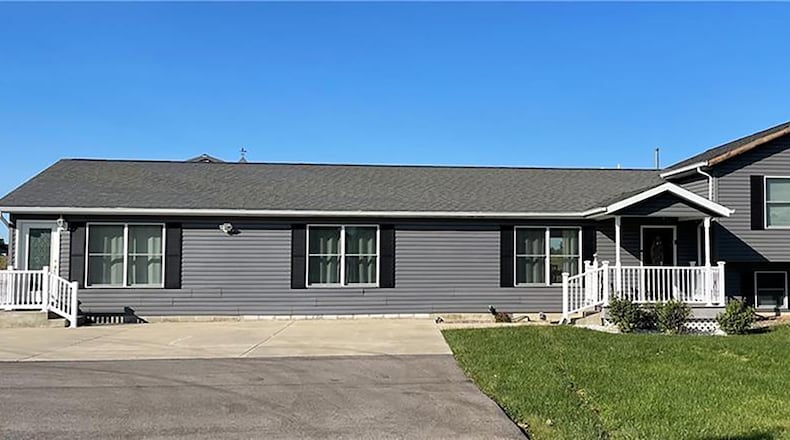 The 3-bedroom tri-level with about 2,060 sq. ft. of living space features a covered porch and an oversized concrete driveway extension that leads to the rear outbuilding/garage. CONTRIBUTED PHOTO