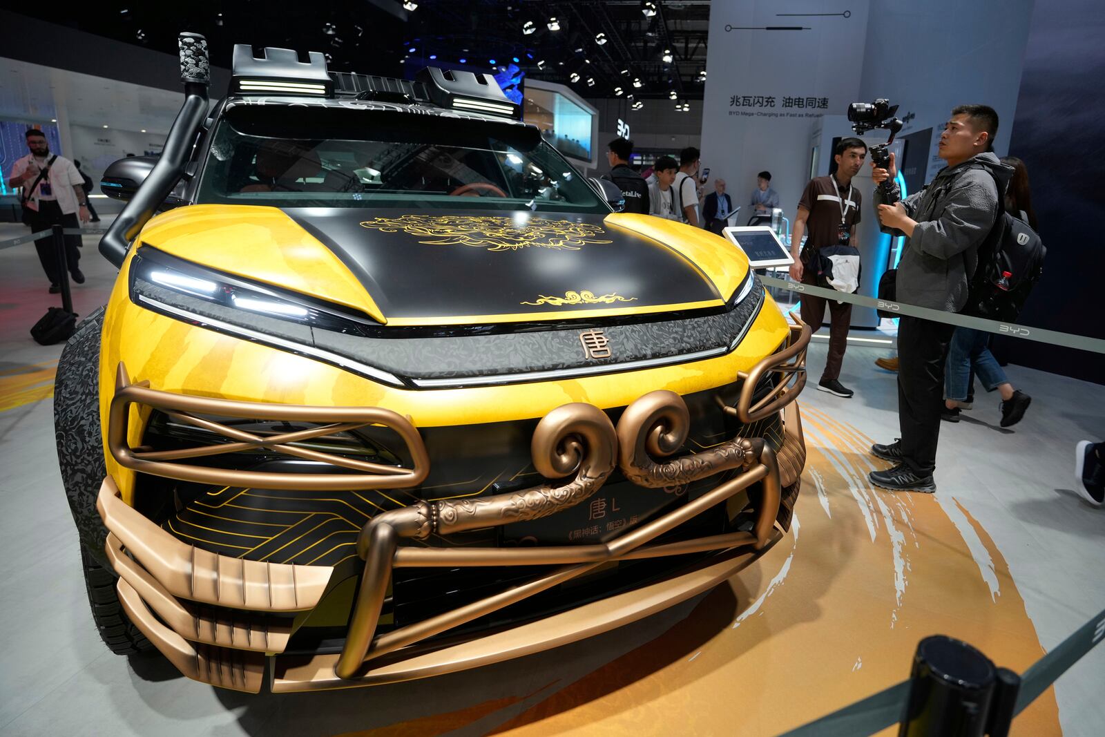 A man films near a special Black Myth:Wukong edition of a Tang L model from BYD during the Shanghai auto show on Wednesday, April 23, 2025. (AP Photo/Ng Han Guan)