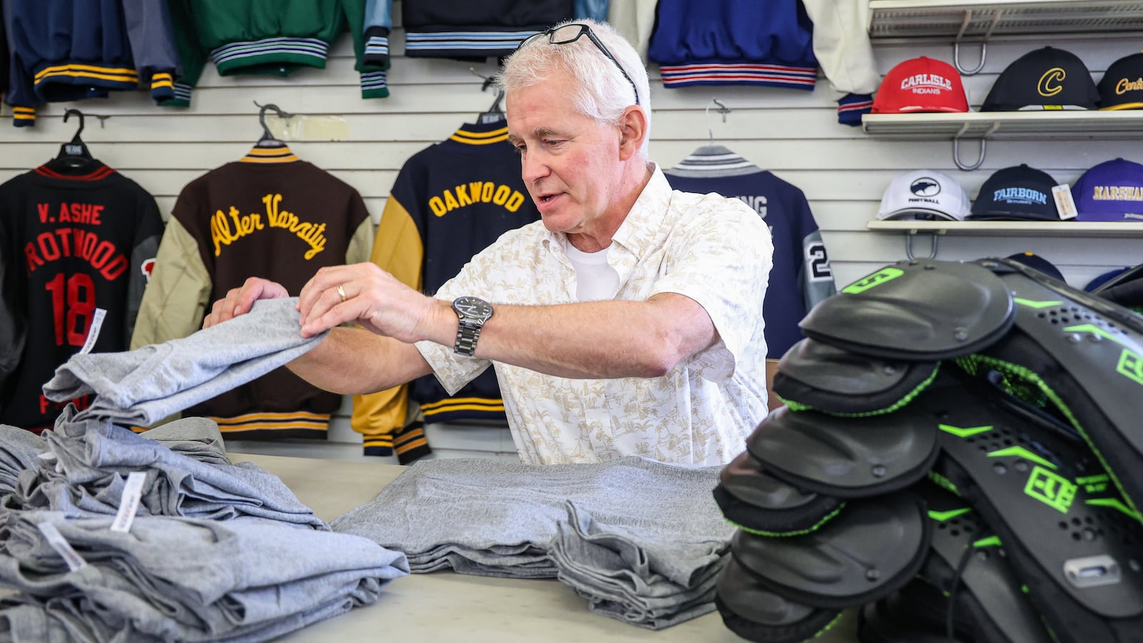 Tuffy Brooks Sporting Goods co-owner Jim Napier folds shirts on Thursday, July 24. Ohio’s upcoming sales tax holiday continues to grow the ways people can save and, this year, the amount of time in which they can do it. The sales tax-free time runs from Aug. 1 to Aug. 14. BRYANT BILLING / STAFF