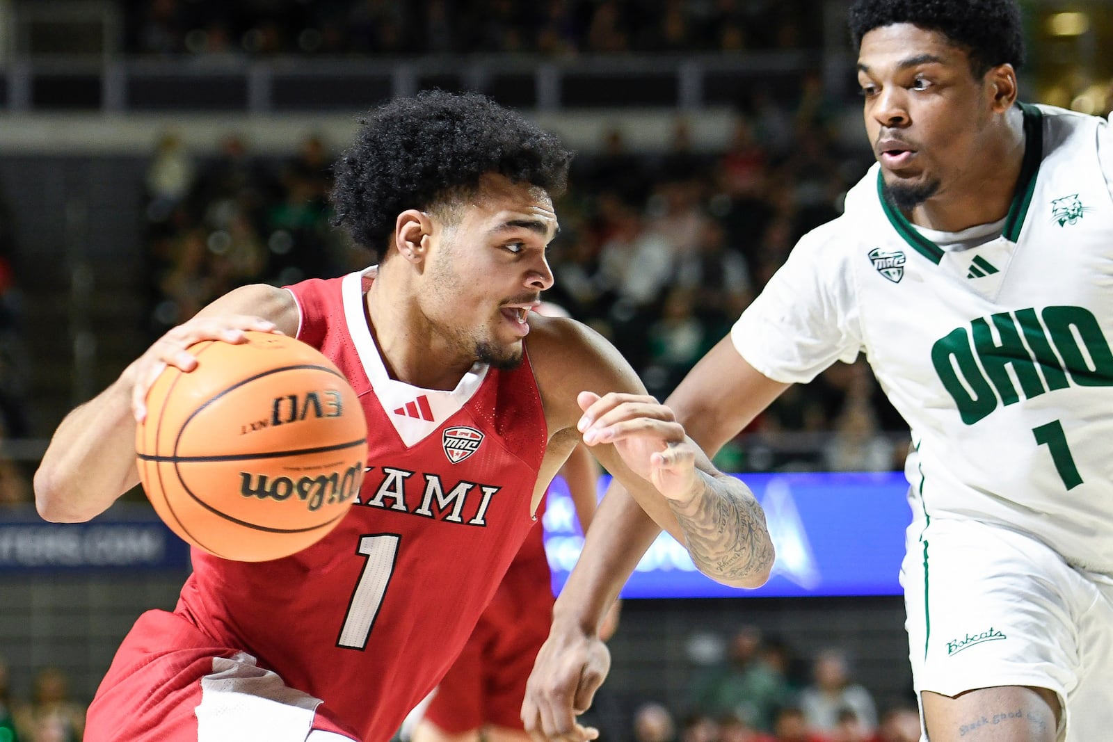 Miami (Ohio) guard Trey Perry (1) drives past Ohio forward Javan Simmons (1) during the first half of an NCAA college basketball game, Friday, March 6, 2026, in Athens, Ohio. (AP Photo/HG Biggs)