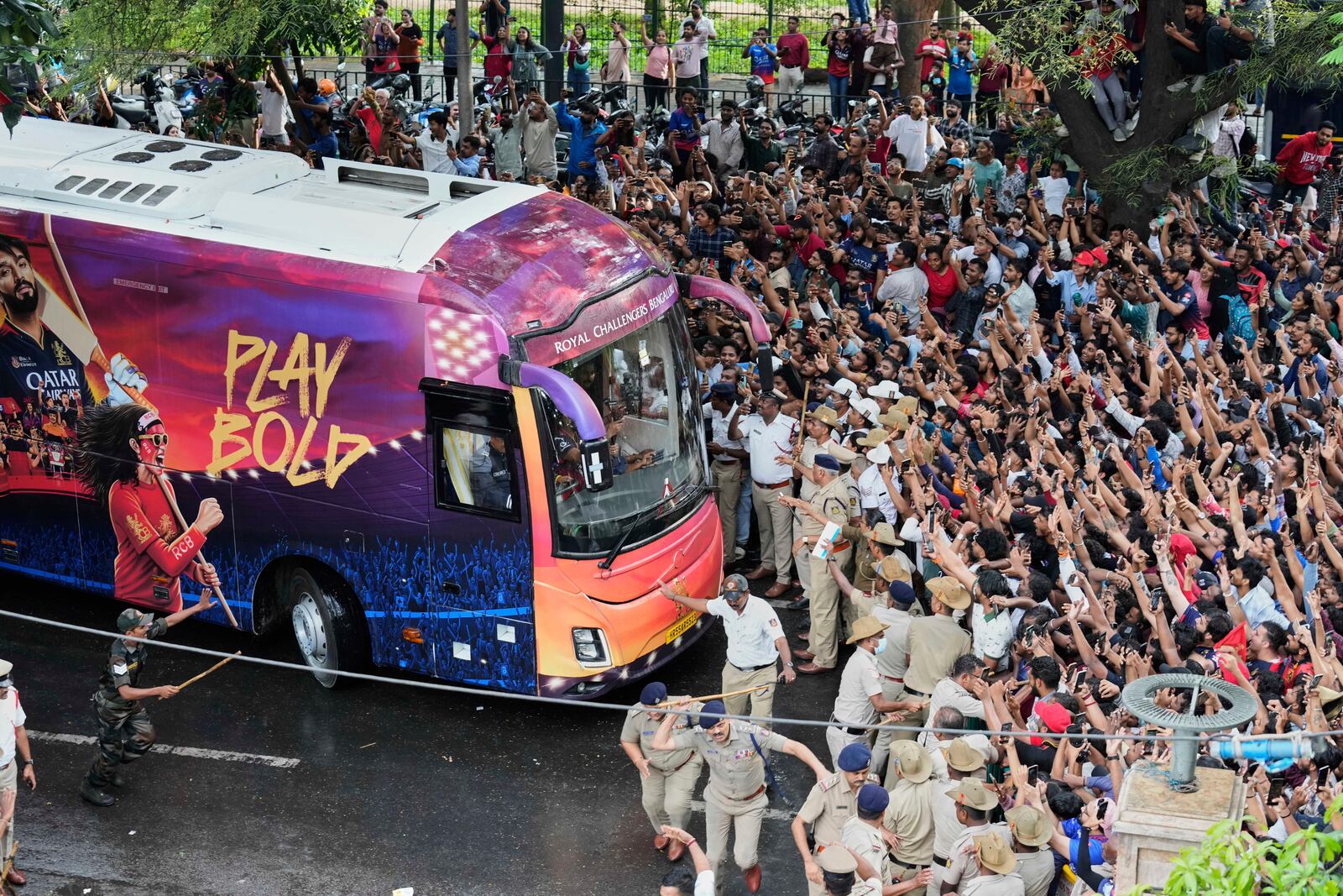 Fans cheer as the bus carrying Royal Challengers Bengaluru cricketers, winners of the Indian Premier League, arrive at the M. Chinnaswamy Stadium in Bengaluru, India, Wednesday, June 4, 2025. (AP Photo/Aijaz Rahi)