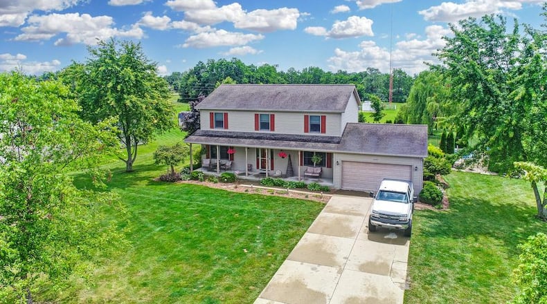 The front of 3297 Maple Grove in Springfield features a large, covered front porch. The home is a two story and has vinyl siding.