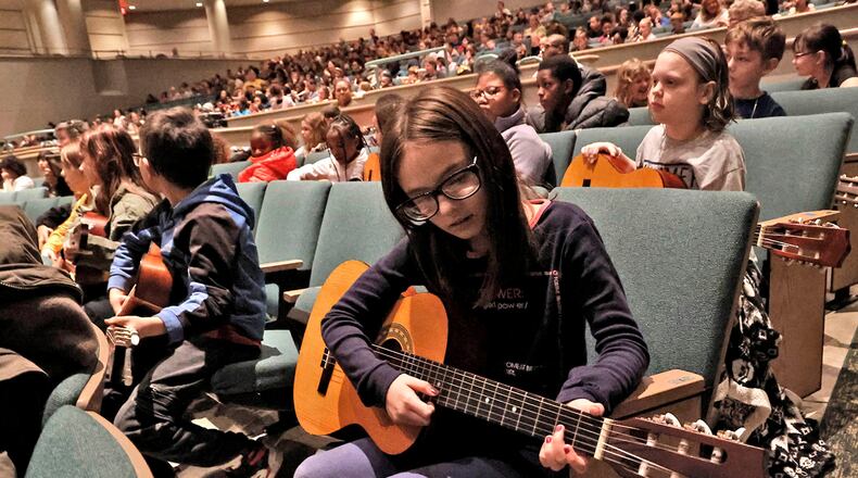 Emma Nehal follows along with the Springfield Symphony Orchestra on a guitar Thursday, Feb. 23, 2023 during the Link Up: The Orchestra Swings music program for students in grades 3-5 in Kuss Auditorium. Most student's brought their recorders to play along with the orchestra but kids in Jim Townsend's music class at Kenwood Elementary brought their guitars. BILL LACKEY/STAFF
