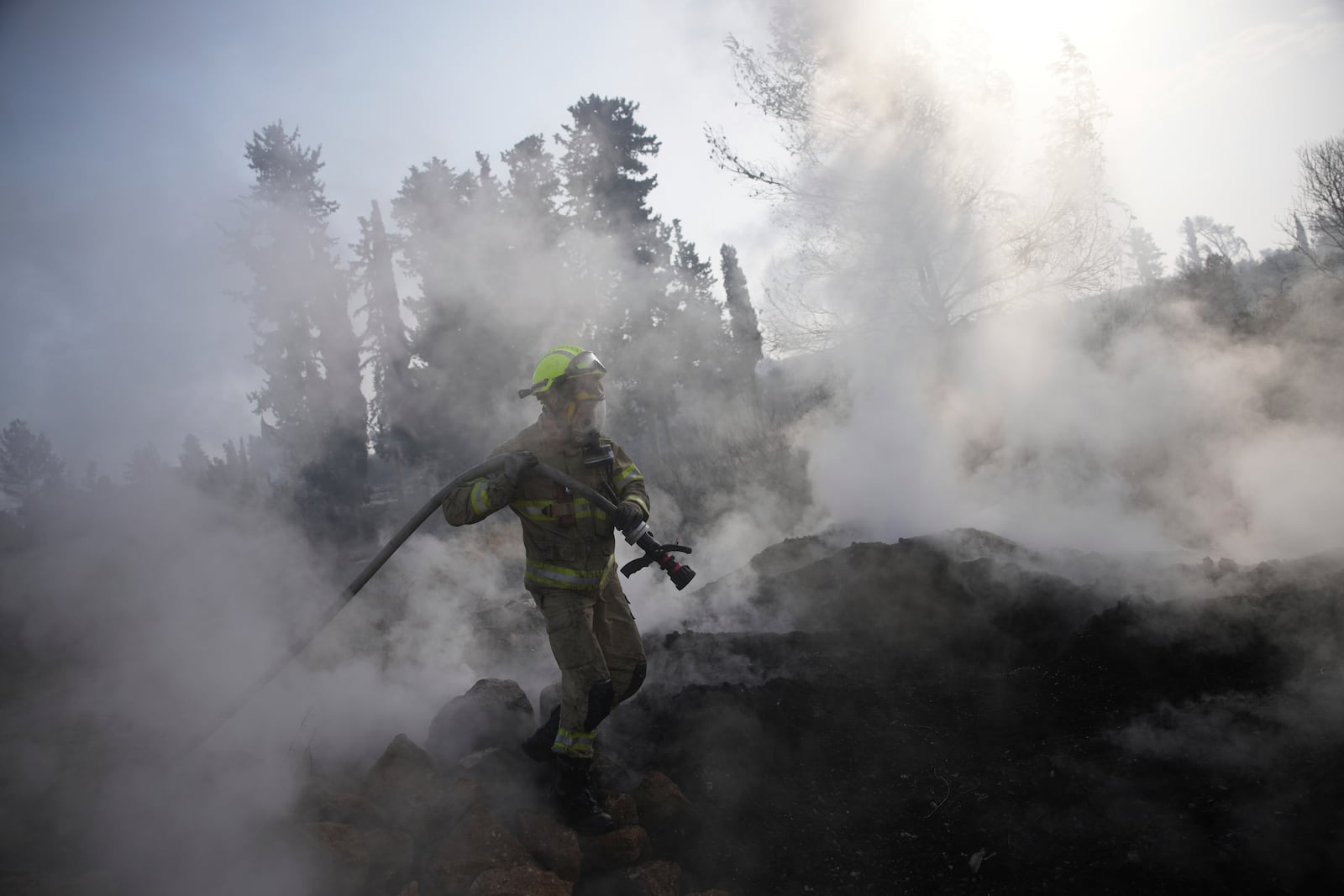 An Israeli firefighter battles a wildfire near Latrun, Israel, outside of Jerusalem, Thursday, May 1, 2025. (AP Photo/Ohad Zwigenberg)