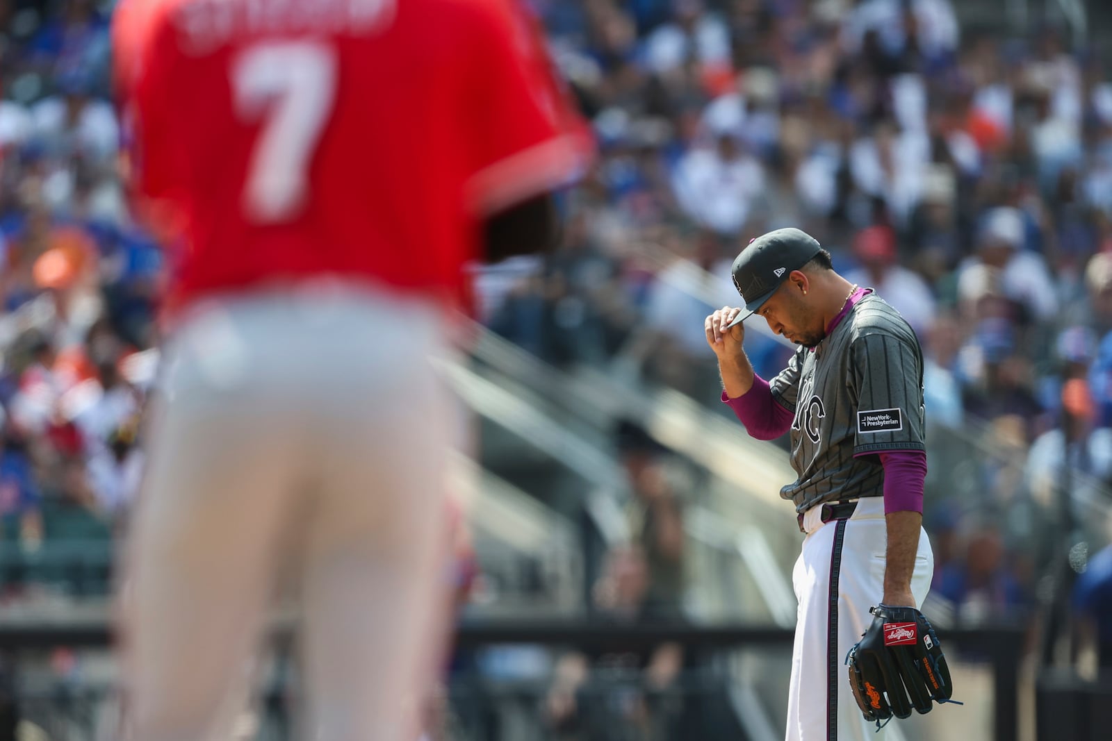 New York Mets pitcher Edwin Díaz, right, looks down while on the mound as he pitches in the eighth inning of a baseball game against the Cincinnati Reds, Sunday, July 20, 2025, in New York. (AP Photo/Heather Khalifa)