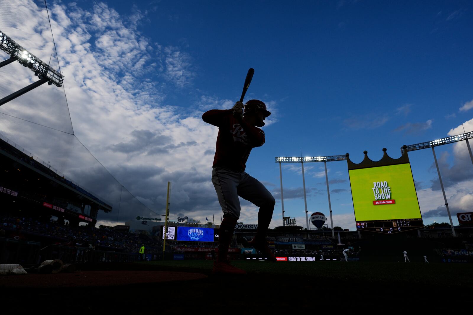 Cincinnati Reds left fielder Austin Hays warms up deck before the second inning of a baseball game against the Kansas City Royals, Wednesday, May 28, 2025, in Kansas City, Mo. (AP Photo/Charlie Riedel)
