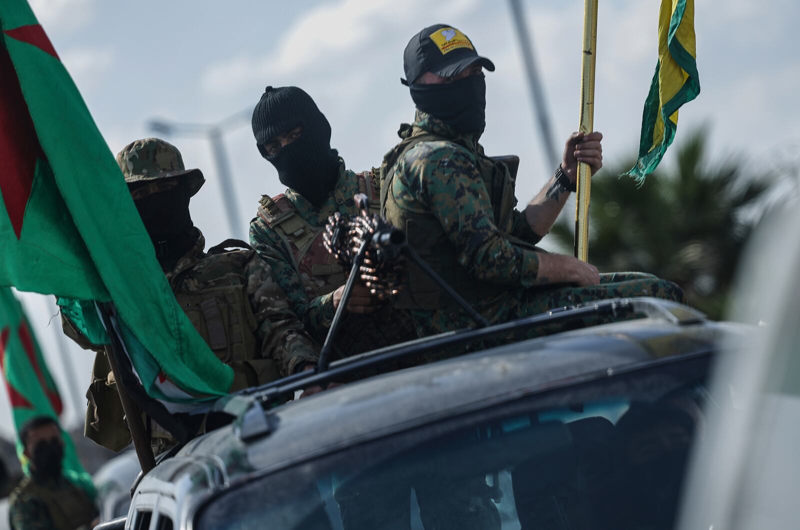 U.S.-backed Kurdish fighters stand on their vehicles, as they withdraw from two neighborhoods in Syria's northern city of Aleppo as part of a deal with the Syrian central government, in Aleppo, Syria, Friday, April 4, 2025. (AP Photo/Ghaith Alsayed)