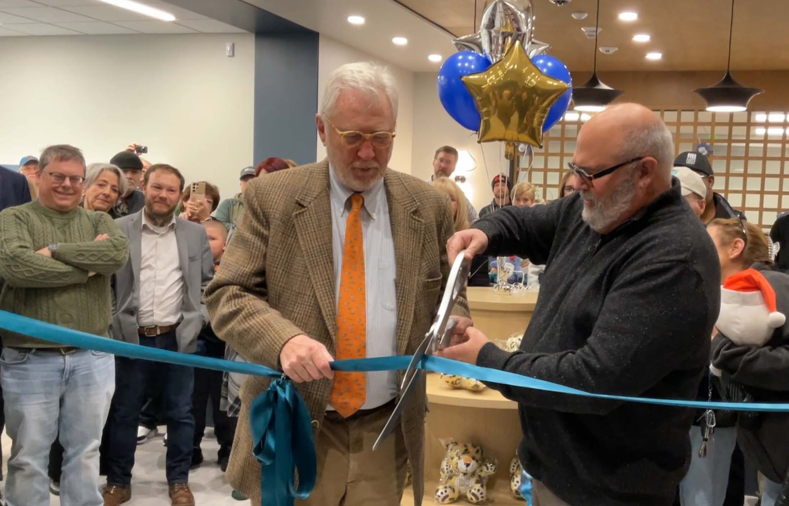 Rick Hoppes, son of Mary Chapman Hoppes, (left) and Clark County Public Library Director Bill Martino (right) cut the ribbon at the main entry of the Northridge Branch during the opening of Northridge’s Mary C. Hoppes Children’s Library. CONTRIBUTED