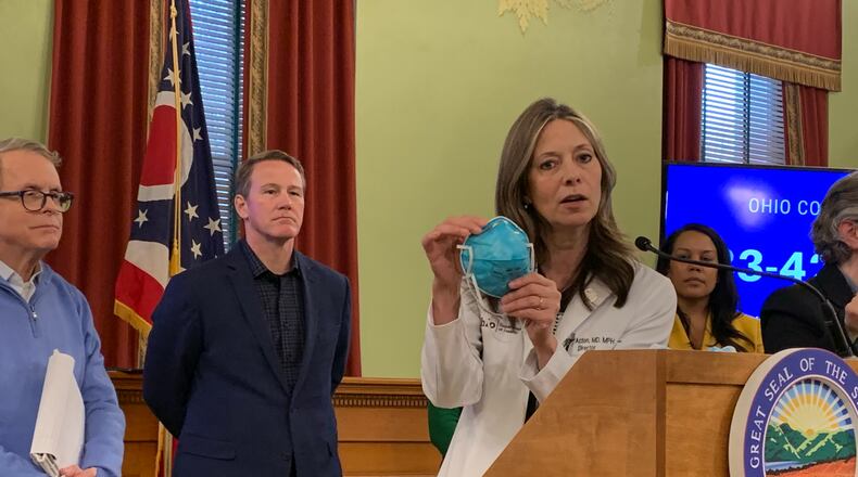 Ohio Department of Health Director Dr. Amy Acton, with Ohio Gov. Mike DeWine and Lt. Gov. Jon Husted, said on Sunday Ohio is facing a shortage of N95 and surgical masks needed to respond to the coronavirus pandemic. Laura Bischoff/Staff