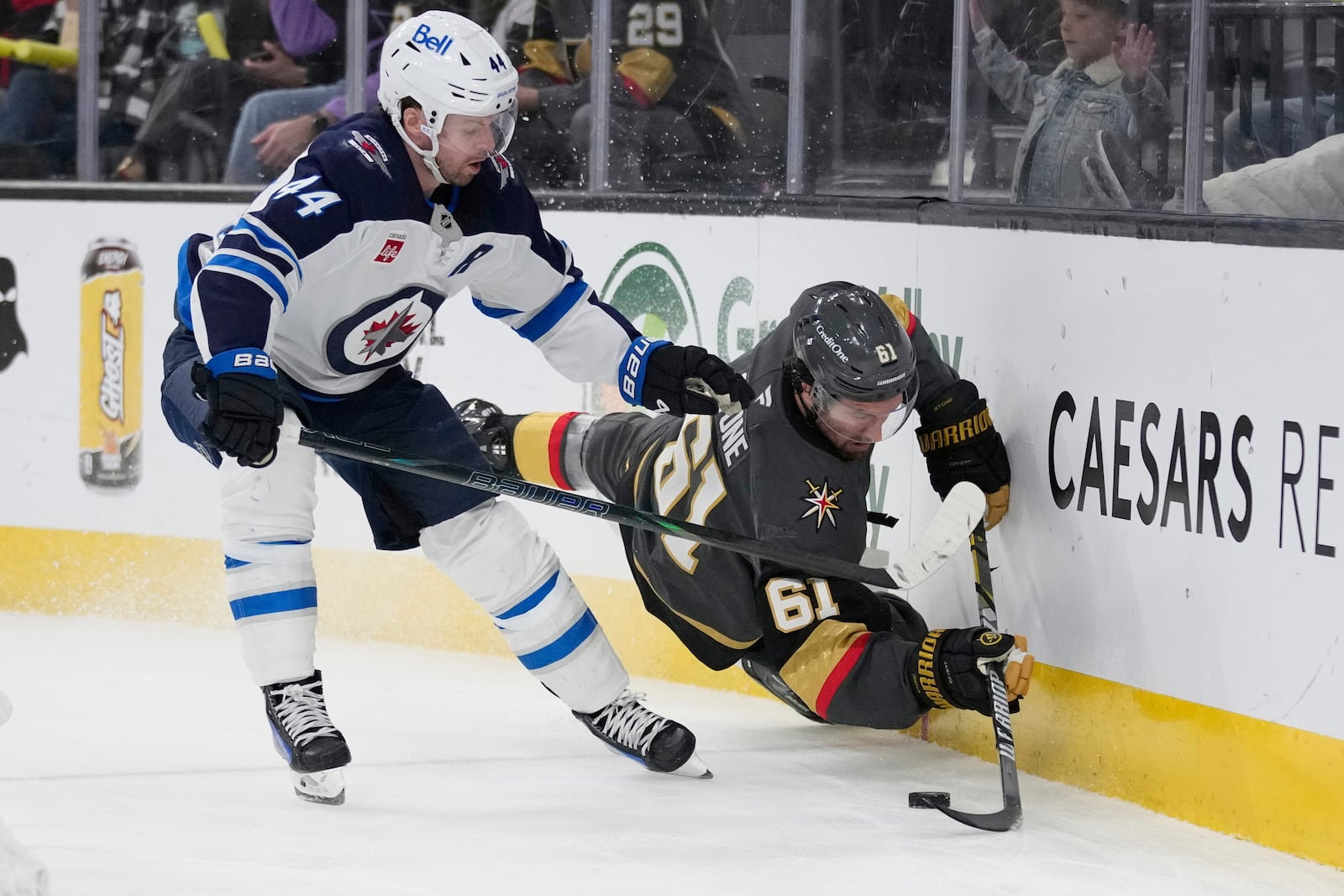 Winnipeg Jets defenseman Josh Morrissey (44) checks Vegas Golden Knights right wing Mark Stone (61) during the second period of an NHL hockey game Thursday, April 3, 2025, in Las Vegas. (AP Photo/John Locher)