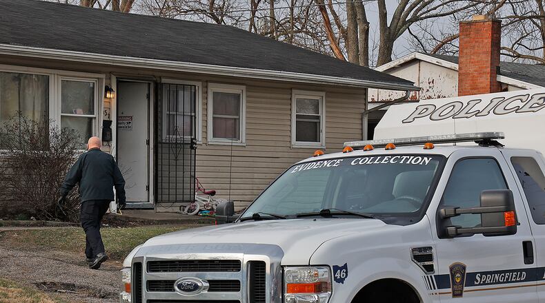 A Springfield police officer enters a house in the 500 block of Mead Lane on March 8, 2023, as officers investigate an overnight shooting at the location. BILL LACKEY/STAFF