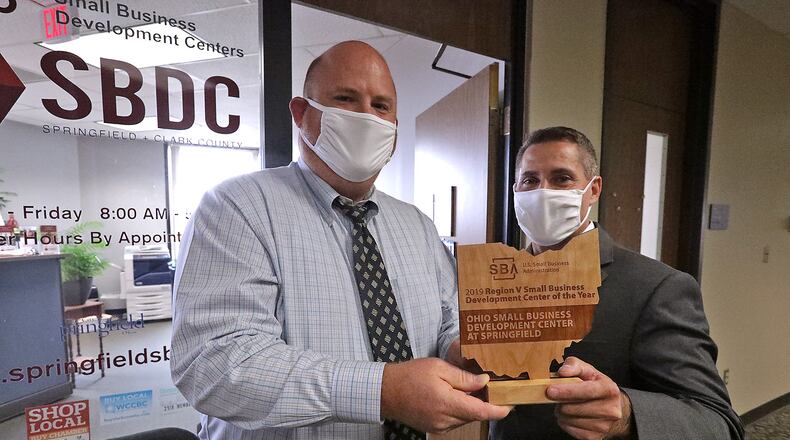 Everett Woodel, right, District Director of the U.S. Small Business Administration, presents Rob Alexander, Executive Director of the Springfield Small Business Development Center, with the award for being the Region 5 Small Business Development Center of the Year Thursday. BILL LACKEY/STAFF