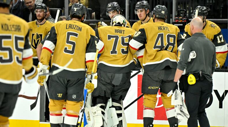 Vegas Golden Knights goaltender Carter Hart (79) is helped off the ice after suffering an apparent injury during the first period of an NHL hockey game against the Columbus Blue Jackets Thursday, Jan. 8, 2026, in Las Vegas. (AP Photo/David Becker)