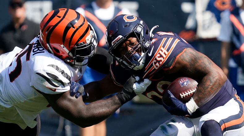 Cincinnati Bengals defensive tackle Larry Ogunjobi (65) pulls Chicago Bears running back David Montgomery down by the jersey during the second half of an NFL football game Sunday, Sept. 19, 2021, in Chicago. (AP Photo/Nam Y. Huh)
