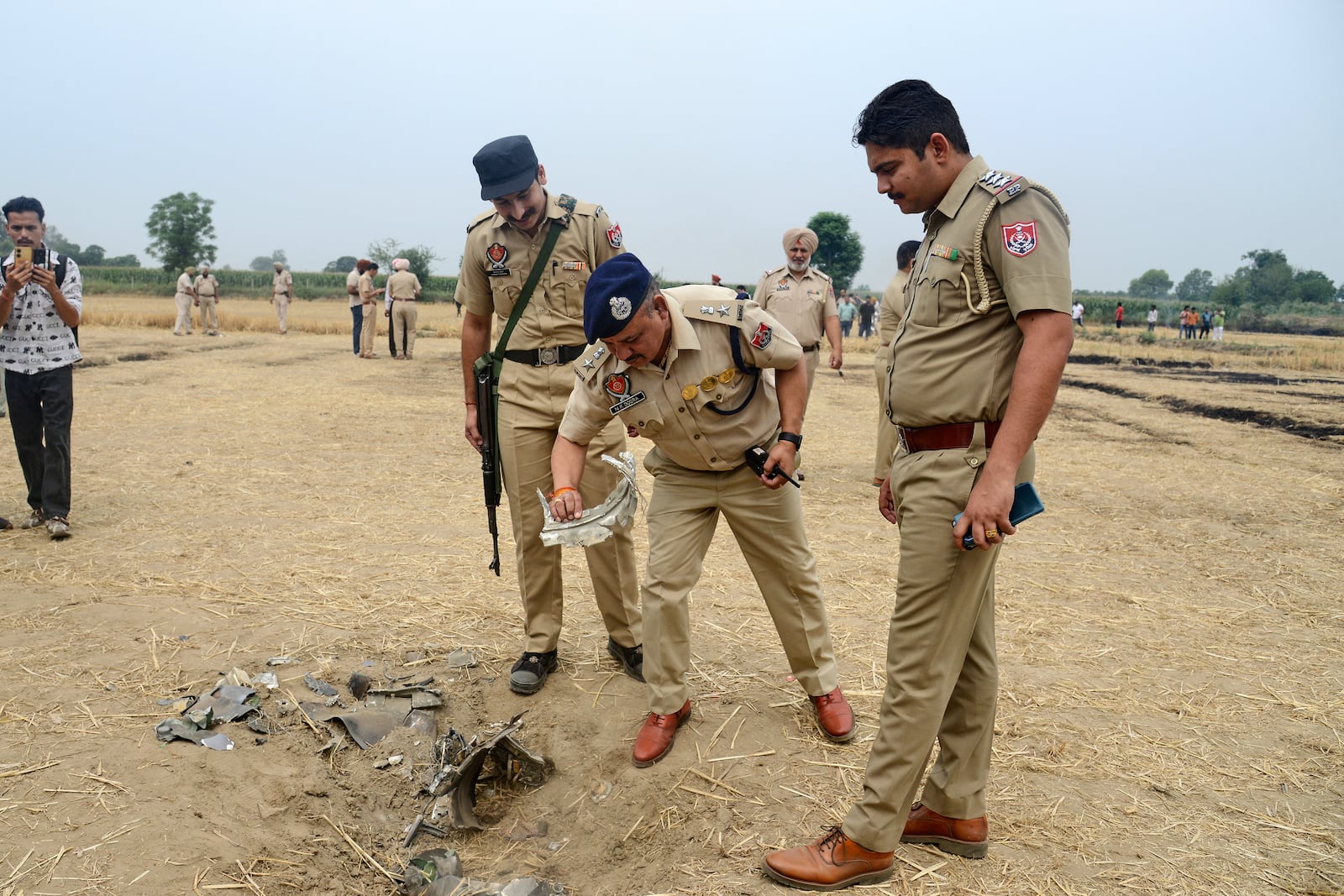 Indian police personnel inspect an object suspected to be parts of a projectile intercepted by the Indian Army at Nahlan village on the outskirts of Jalandhar, India, Saturday, May 10, 2025. (AP Photo)