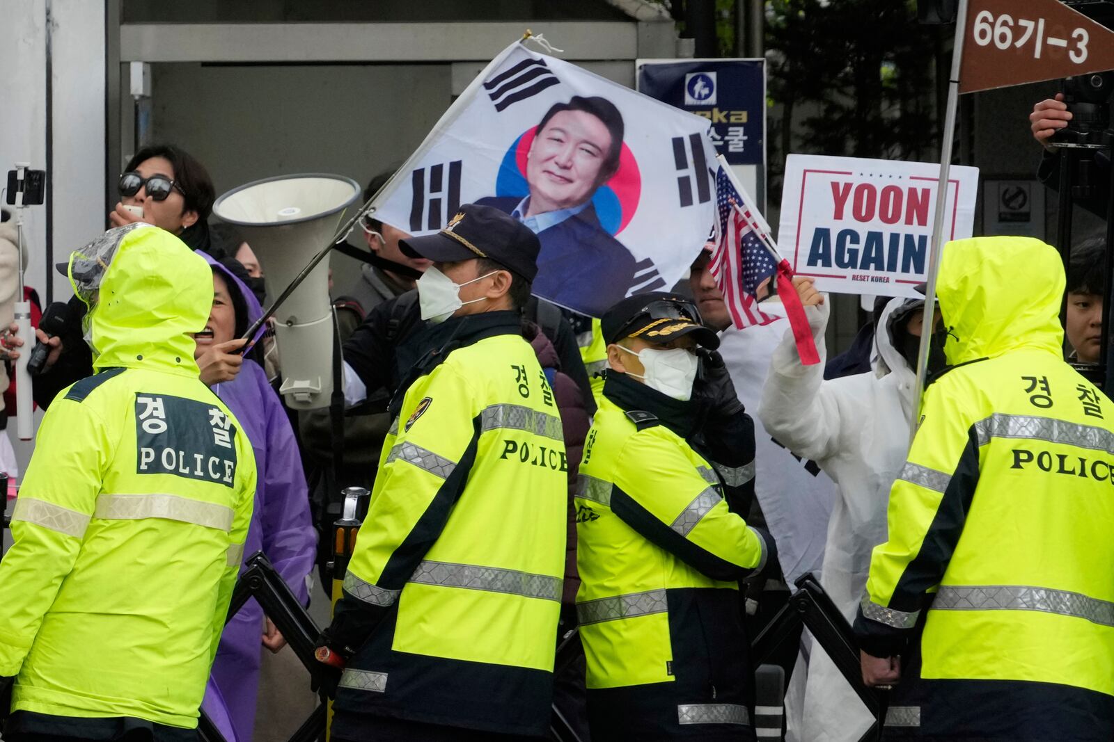 Supports of South Korea's ousted President Yoon Suk Yeol stand to call for the cancellation of his removal in front of the Seoul Central District Court in Seoul, South Korea, Monday, April 14, 2025. (AP Photo/Ahn Young-joon)