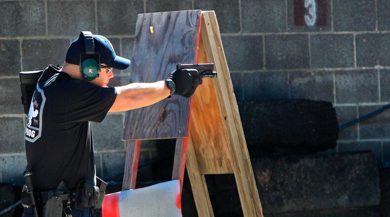 FILE—In this file photo from Oct. 8, 2013, police officer JR Lavish shoots a pistol during a police training exercise at the Eagle Creek Firearms Training Facility in Findlay, Ohio. After a 2016 shooting at Madison Local Schools in southwestern Ohio, a group of parents sued the district in September 2018 to prevent teachers from being armed without extensive training. The Ohio Supreme Court ruled Wednesday, June 23, 2021 that armed school employees must undergo an approved basic peace-officer-training program or have 20 years experience as a police officer. (Kelly Wilkinson/The Indianapolis Star via AP)