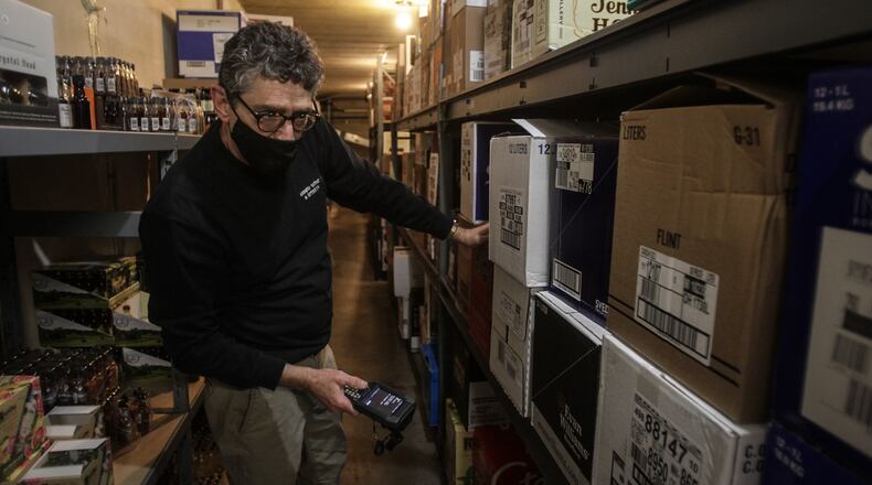 Arrow Wine & Spirits liquor manager Chuck Gress goes through inventory in the basement of the store on Far Hill Avenue in Kettering. Liquor sales in Ohio increased in 2020, fueled by a pandemic-induced retail surge that found people creating cocktails at home rather than buying them at their local bar or restaurant. JIM NOELKER/STAFF