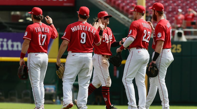 The Reds celebrate a victory against the Brewers on Wednesday, May 11, 2022, at Great American Ball Park in Cincinnati. David Jablonski/Staff