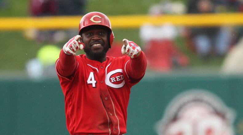 The Reds’ Brandon Phillips points to a teammate at third base after an RBI hit in the third inning against the Pirates in an exhibition game at Victory Field in Indianapolis on Saturday, April 2, 2016. David Jablonski/Staff