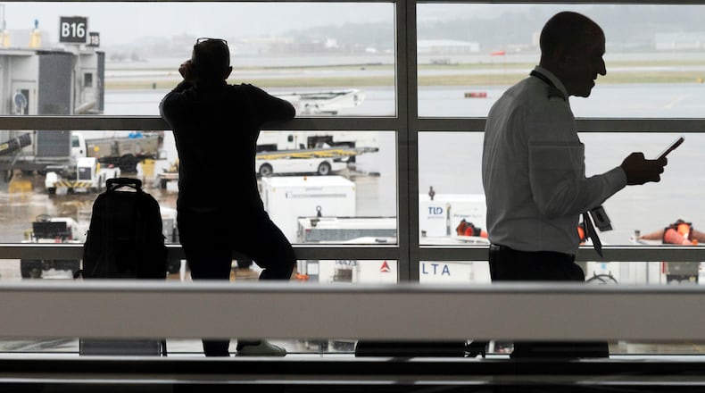 People wait in a departure terminal at Ronald Reagan National Airport, in Arlington, Va., Monday, March 16, 2026. (AP Photo/Cliff Owen)