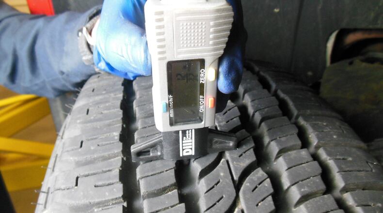A digital tread depth a-gauge being used to measure the tread depth of tires. Most shops perform a safety check including checking and recording the tread depth of the tires, whenever the vehicle is in the shop for any service or repairs. James Halderman photo